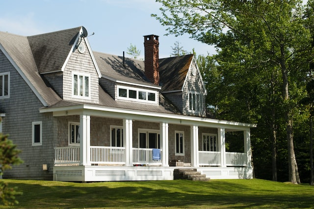 Exterior of a large grey house with a white porch